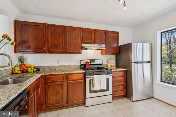a kitchen with stainless steel appliances granite countertop a stove sink and cabinets