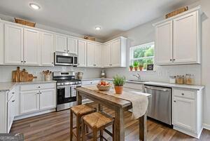 343 Shoals Trail Dallas, GA 30132 - Photo 5 of 10 a kitchen with a sink white cabinets and appliances