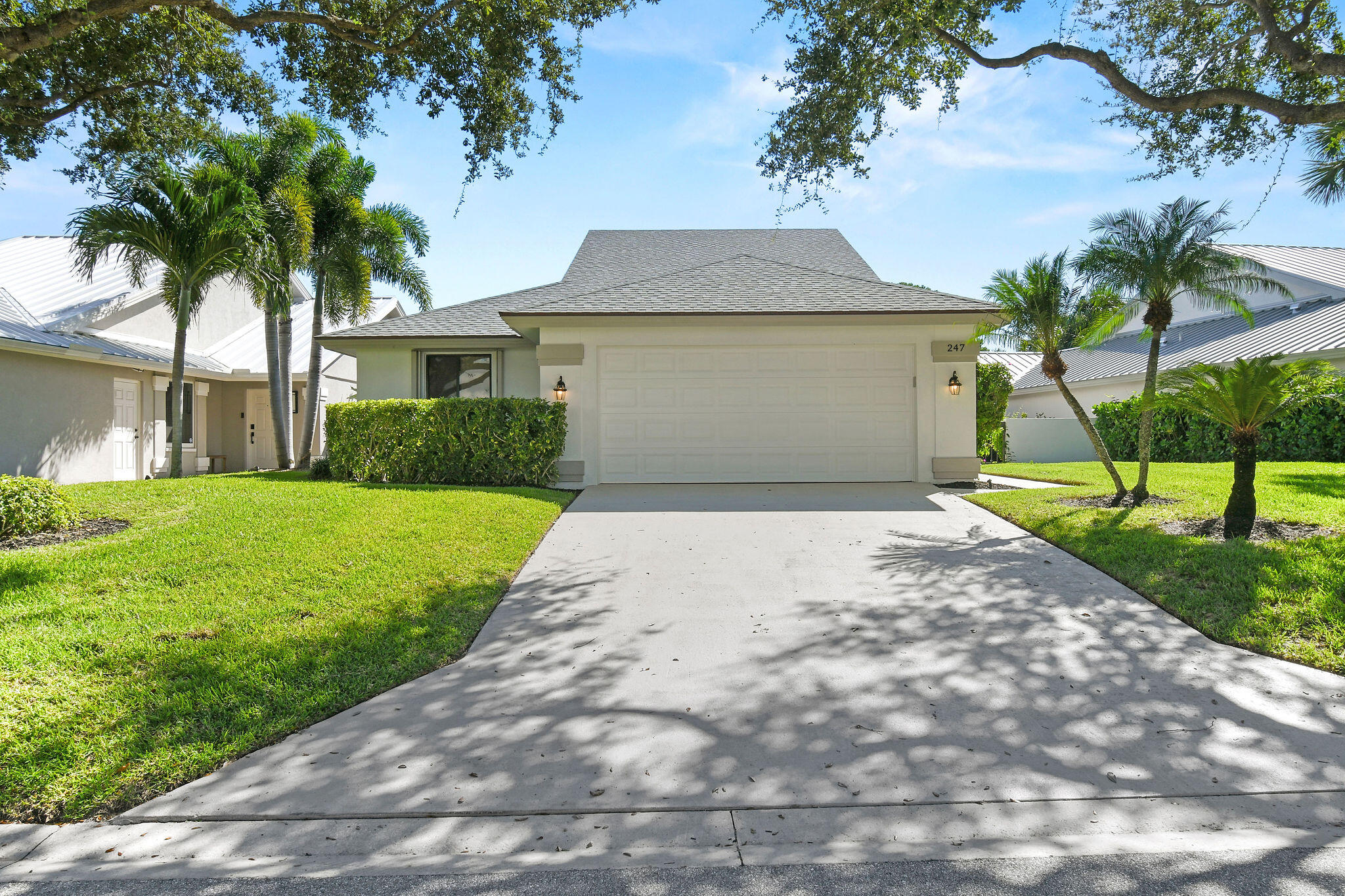 247 Ridge Road Jupiter, FL 33477 - Photo 1 of 28 a front view of a house with a yard and garage