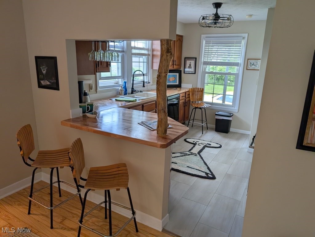 5860 Haber Road Vermilion, OH 44089 - Photo 16 of 31 Kitchen with a kitchen breakfast bar, dishwashing machine, an office area, brown cabinets, and a peninsula