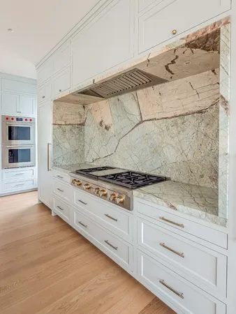 a en suite bathroom with a granite countertop double vanity sink a mirror and a bathtub