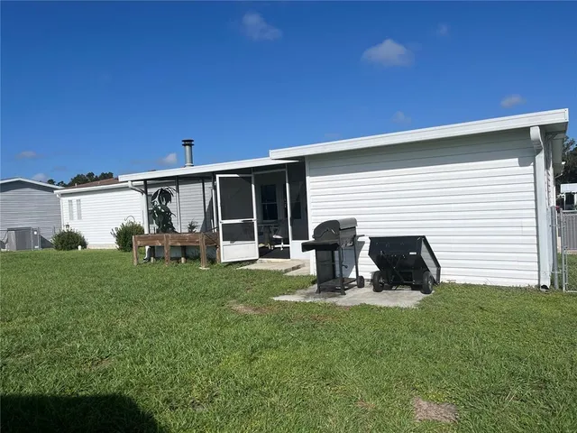 a view of a backyard with table and chairs and wooden fence