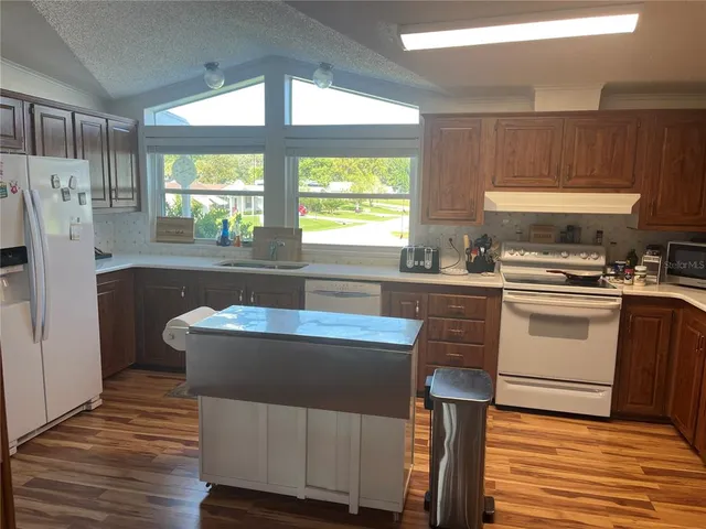 a kitchen with a table chairs refrigerator and window