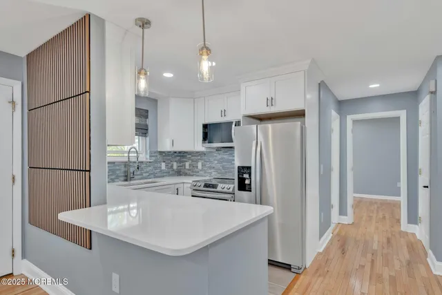 a kitchen with refrigerator and white cabinets