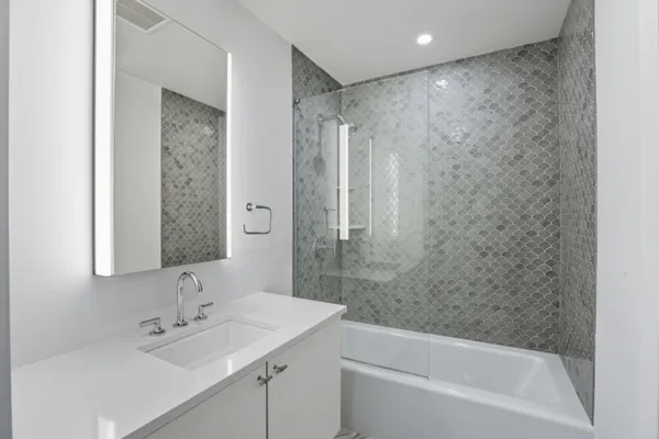 a bathroom with a bathtub shower sink vanity and a toilet