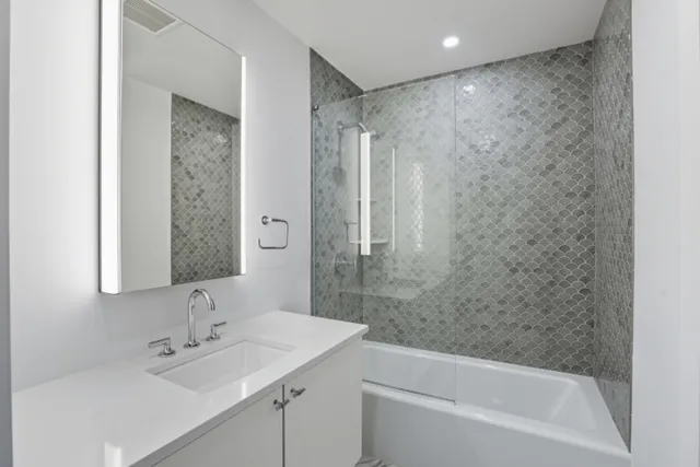 a bathroom with a bathtub shower sink vanity and a toilet