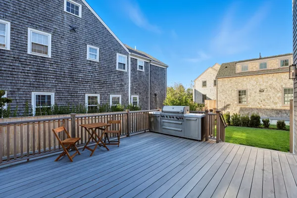 a view of house with yard and deck