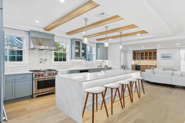 a kitchen with stainless steel appliances granite countertop a kitchen island a stove and a sink