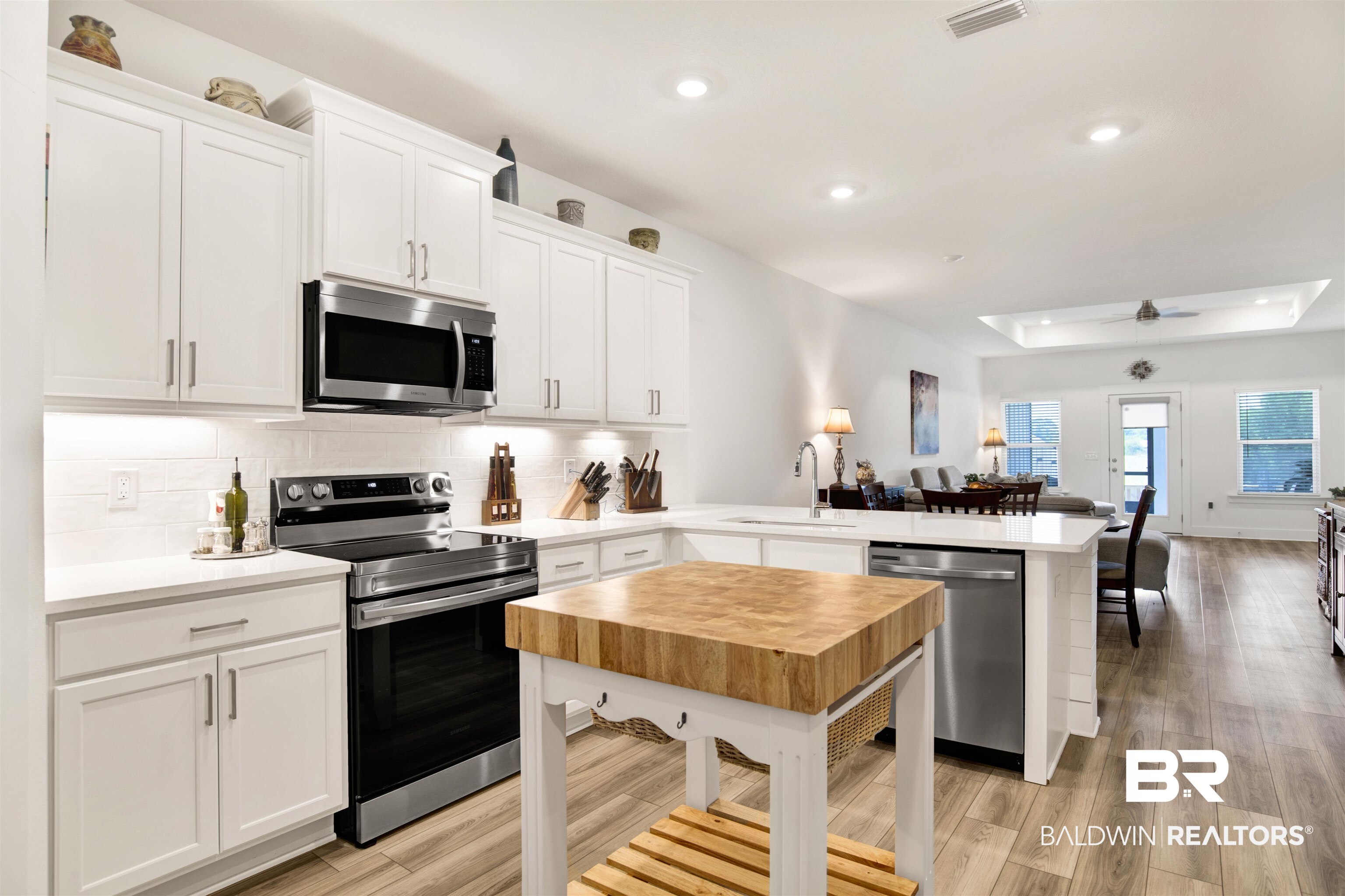 9894 Weller Cove Foley, AL 36535 - Photo 23 of 23 Kitchen with a peninsula, stainless steel appliances, open floor plan, tasteful backsplash, and a tray ceiling