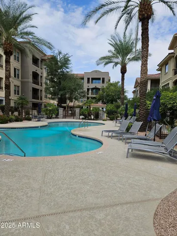 a view of a swimming pool with a bench and trees