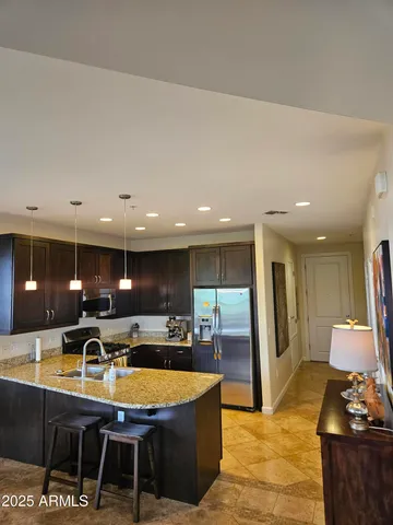 a kitchen with stainless steel appliances dining table a sink and a refrigerator