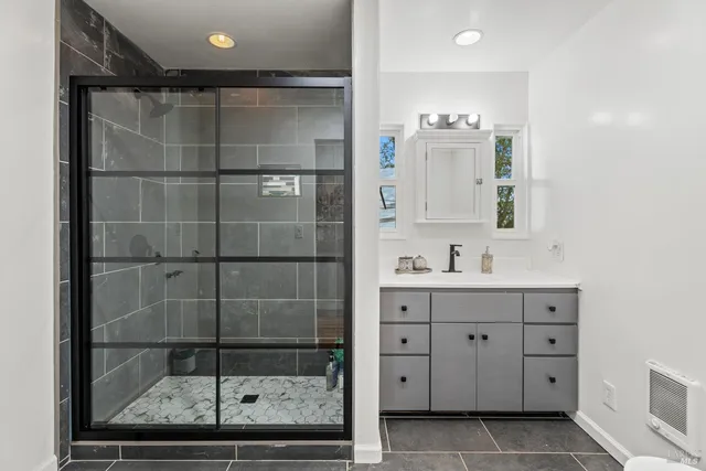 a bathroom with a shower sink and mirror