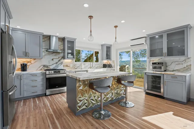 a kitchen with stainless steel appliances kitchen island granite countertop a stove a sink and a refrigerator