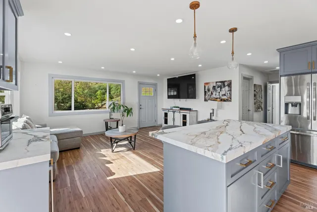 a open kitchen with stainless steel appliances granite countertop a sink stove and wooden floor