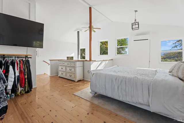 a spacious bedroom with a bed and a flat screen tv