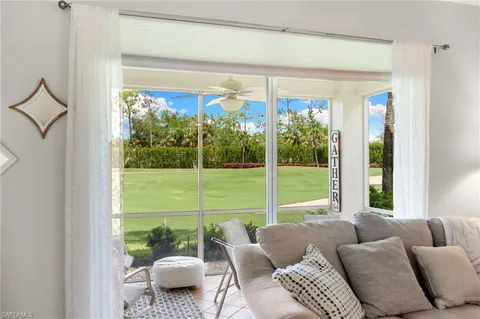 a living room with furniture and a floor to ceiling window