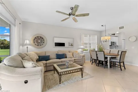 a living room with furniture a clock and a window