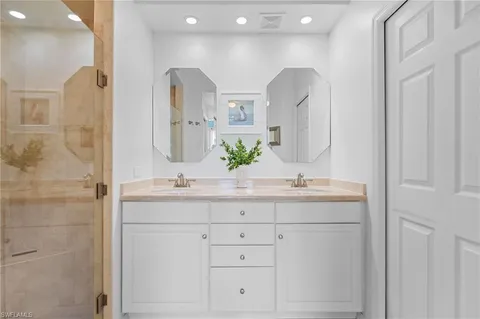a bathroom with double vanity sinks and a mirror
