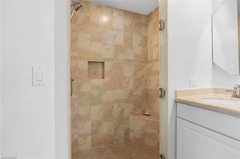 a bathroom with a granite countertop shower and a sink