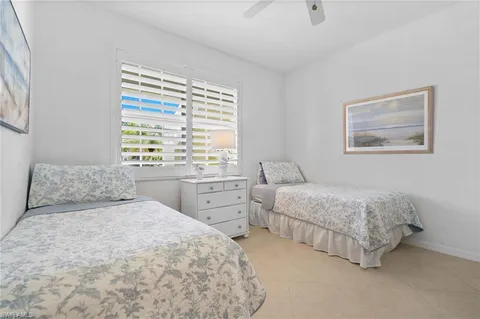 a bedroom with two beds and a window