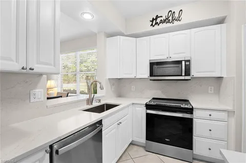 a kitchen with stainless steel appliances a stove microwave and sink
