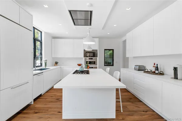 a kitchen with granite countertop a sink a counter space appliances and cabinets
