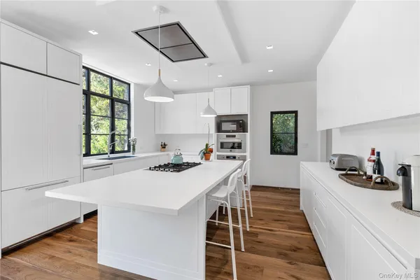 a kitchen with a sink a stove a refrigerator and white cabinets