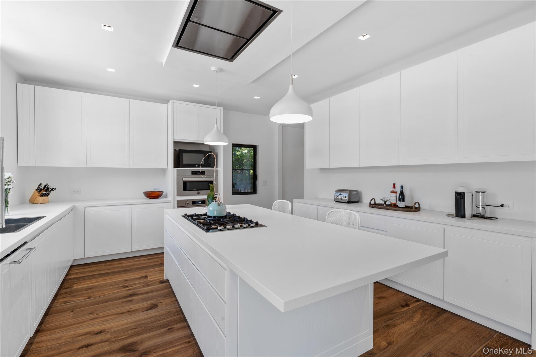 15 Atterbury Road Southampton, NY 11968 - Photo 17 of 46 a kitchen with stainless steel appliances a stove a sink a refrigerator white cabinets and wooden floor
