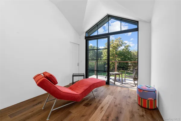 a living room with furniture a wooden floor and a floor to ceiling window