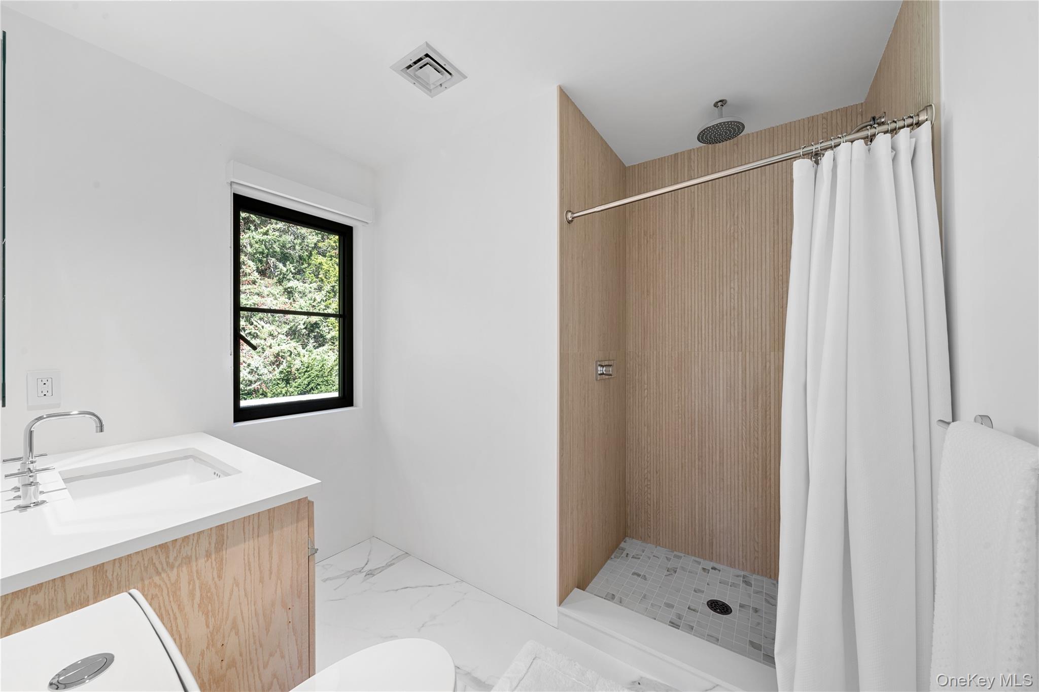 15 Atterbury Road Southampton, NY 11968 - Photo 25 of 46 a bathroom with a shower and a sink