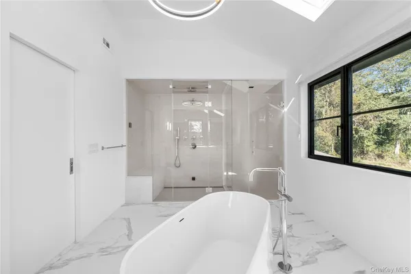 a spacious bathroom with a bathtub shower and sink