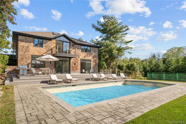 a front view of a house with swimming pool having outdoor seating