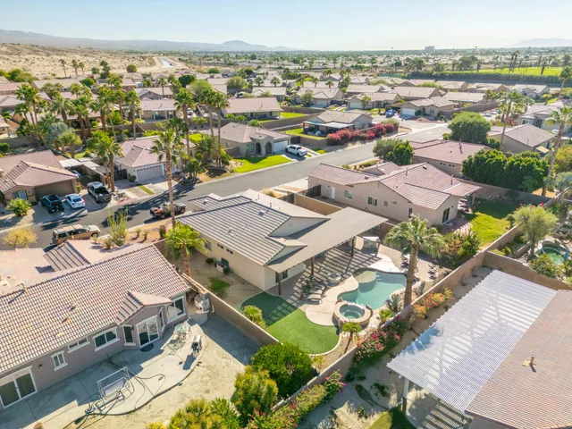 an aerial view of a city with lots of residential buildings and mountain view in back