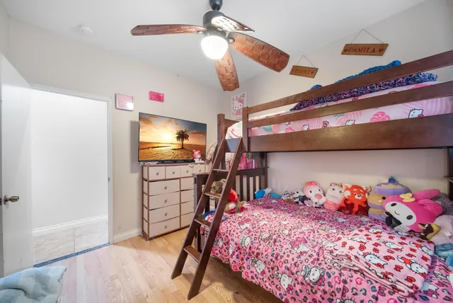 a bedroom with a bed and a flat tv screen on dresser