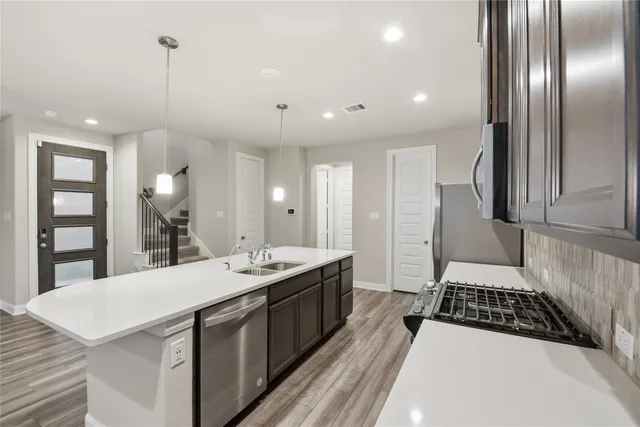 a kitchen with stainless steel appliances granite countertop a sink stove and refrigerator