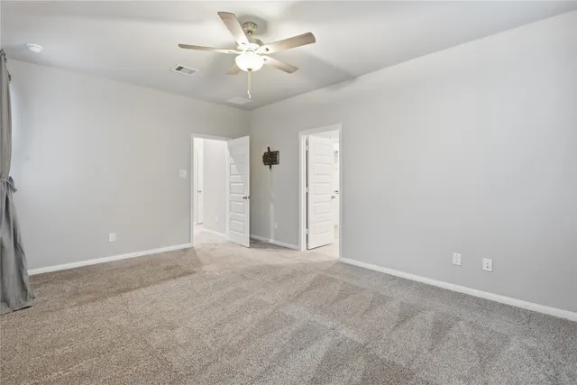 an empty room with a ceiling fan and a fan