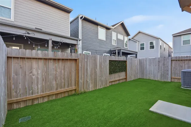 a view of backyard with potted plants and large tree