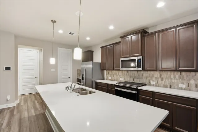 a large kitchen with kitchen island a sink stainless steel appliances and cabinets