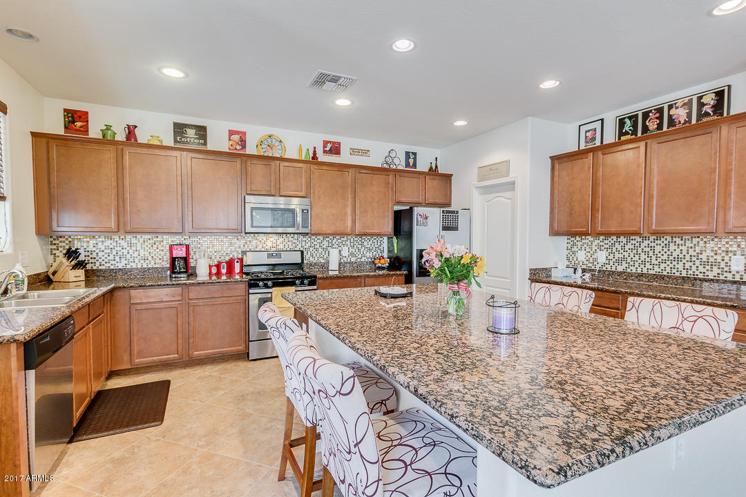 2099 South Martingale Road Gilbert, AZ 85295 - Photo 13 of 43 a kitchen with stainless steel appliances granite countertop a sink counter space and cabinets