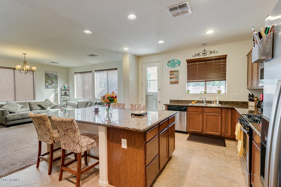 2099 South Martingale Road Gilbert, AZ 85295 - Photo 15 of 43 a kitchen with counter top space appliances and a center island