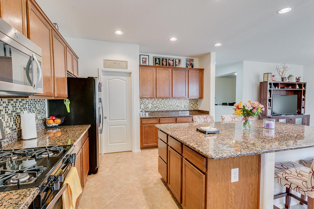 2099 South Martingale Road Gilbert, AZ 85295 - Photo 16 of 43 a kitchen with stainless steel appliances granite countertop a sink stove and refrigerator