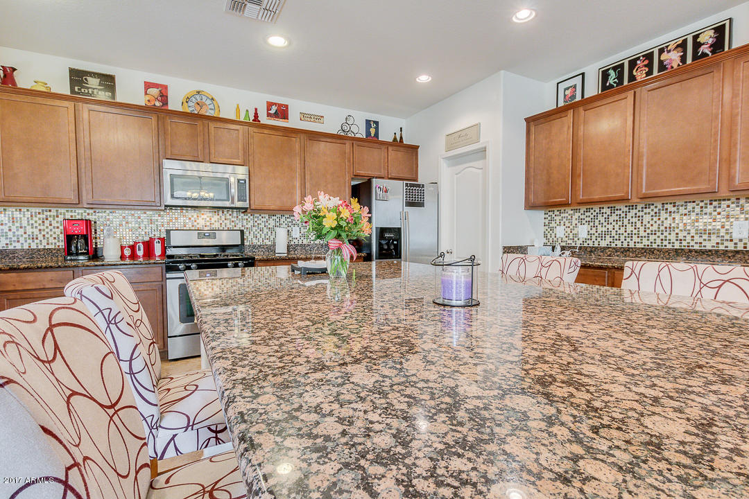 2099 South Martingale Road Gilbert, AZ 85295 - Photo 20 of 43 a kitchen with stainless steel appliances granite countertop a stove a sink and a microwave