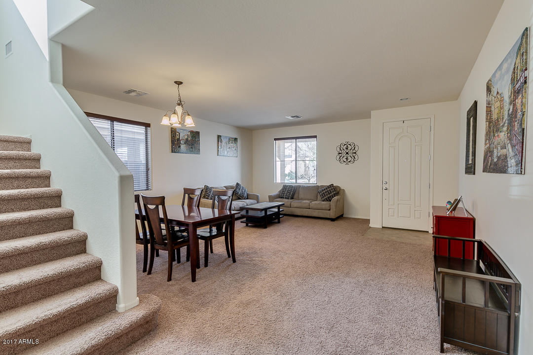 2099 South Martingale Road Gilbert, AZ 85295 - Photo 5 of 43 a living room with furniture and a dining table