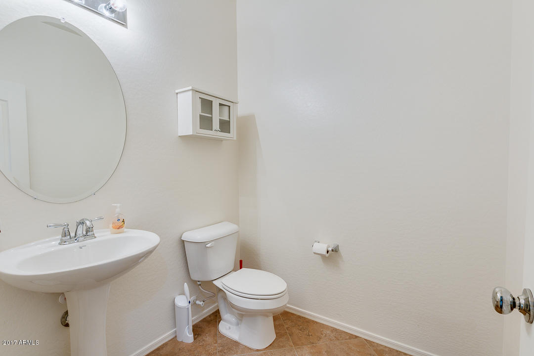 2099 South Martingale Road Gilbert, AZ 85295 - Photo 7 of 43 a bathroom with a toilet a sink and mirror
