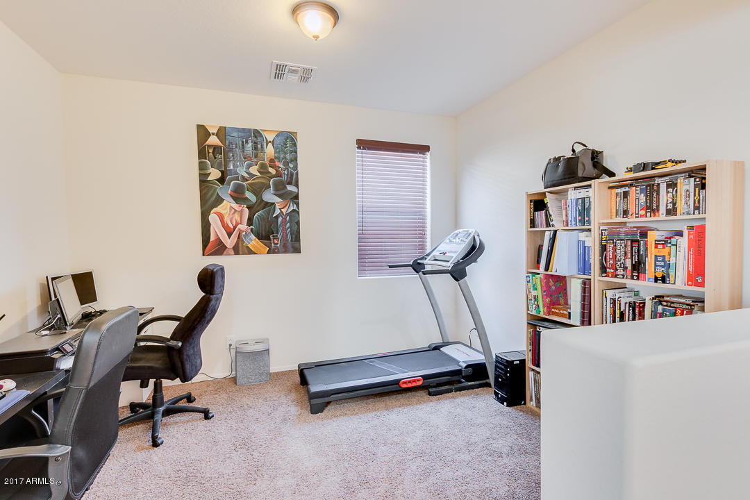 2099 South Martingale Road Gilbert, AZ 85295 - Photo 8 of 43 a room with gym equipment and a book shelf