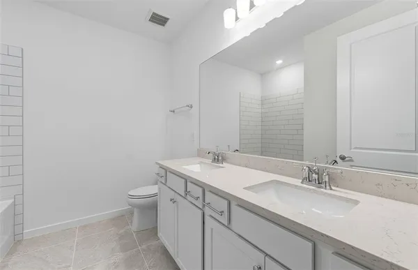 a bathroom with a granite countertop sink a toilet and a mirror