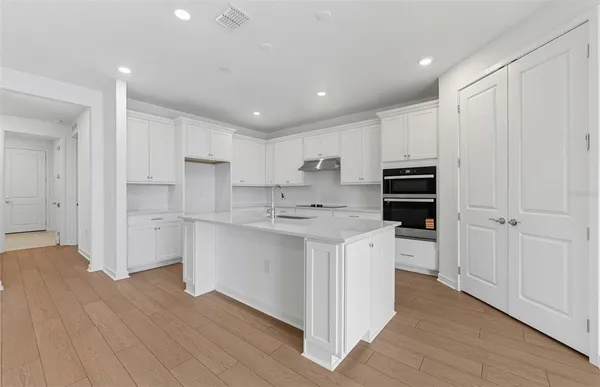 a kitchen with white cabinets and stainless steel appliances