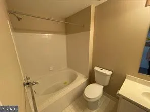 a white toilet sitting next to a bath tub