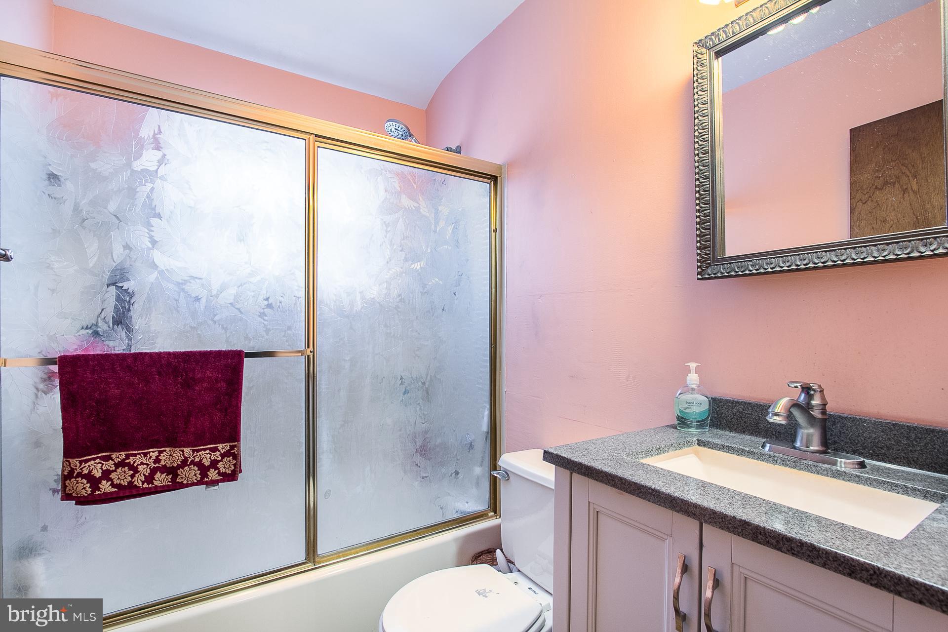 4444 Fenor Road Baltimore, MD 21227 - Photo 13 of 26 a bathroom with a granite countertop sink a toilet and shower