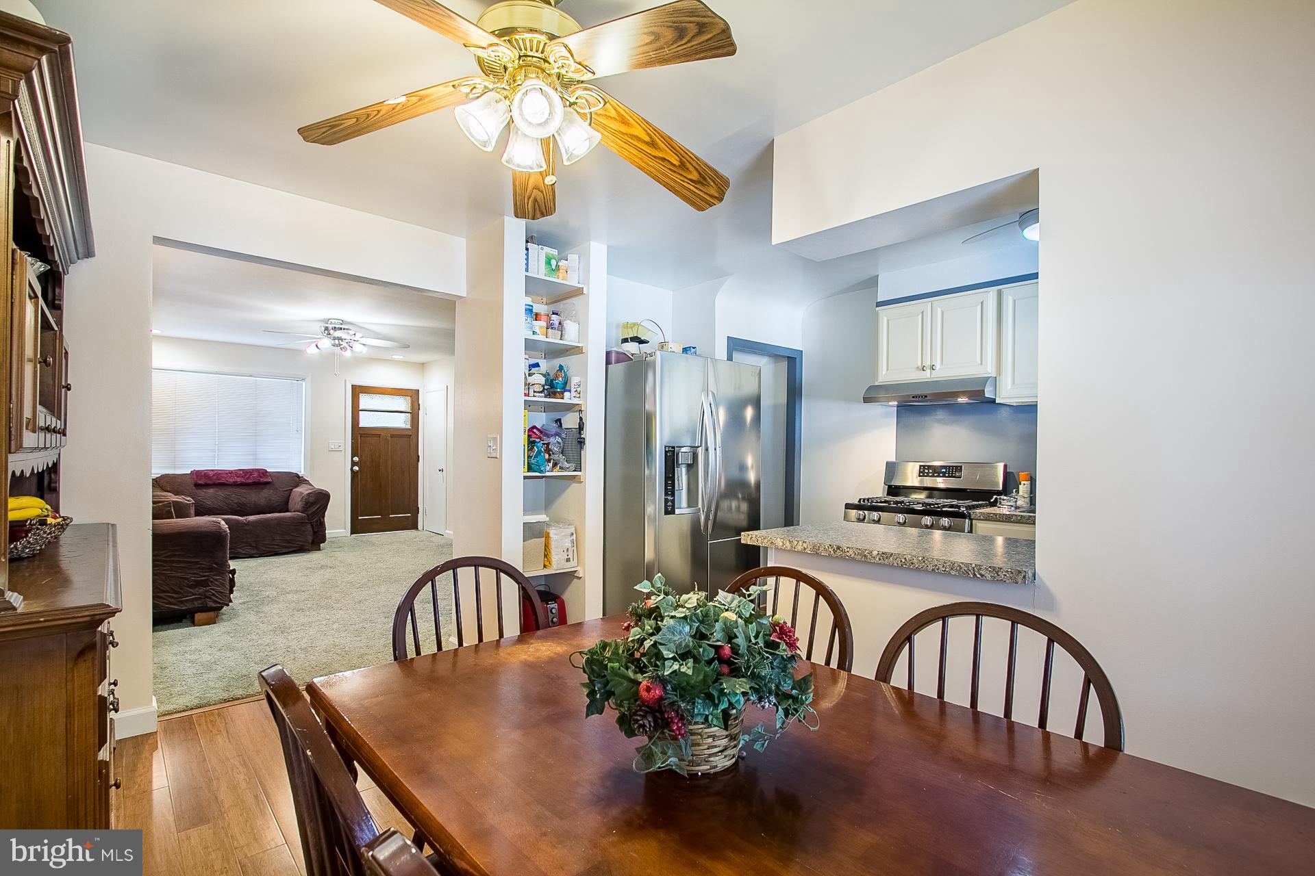 4444 Fenor Road Baltimore, MD 21227 - Photo 6 of 26 a kitchen with stainless steel appliances granite countertop a stove a refrigerator a stove a sink dishwasher with a dining table and chairs